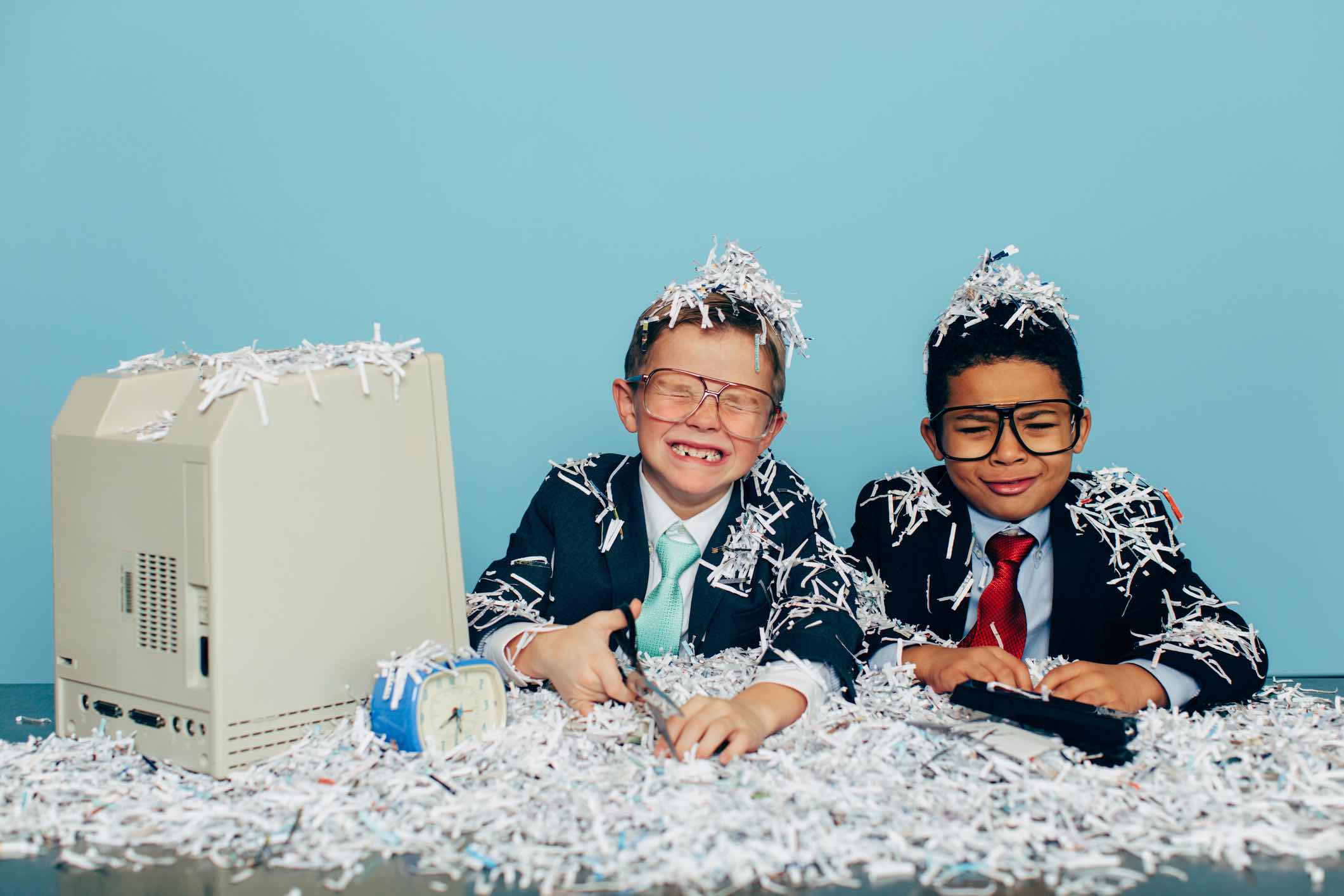 Two young boys and businessman in business attire and glasses sit at an office desk with lots of shredded paper all over them. The business they operate has just been compromised and they are victims of identity theft. They are crying and don't know what to do. Retro style.